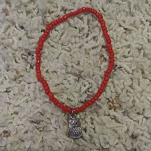 Red bracelet with a silver owl